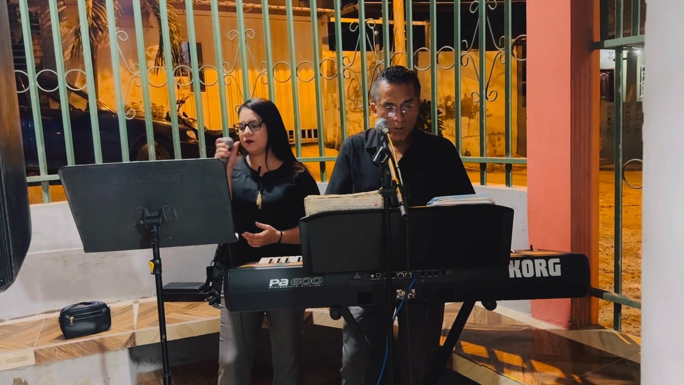 El Coro Yo te Extrañaré interpretando en una presentación nocturna con teclado y voz