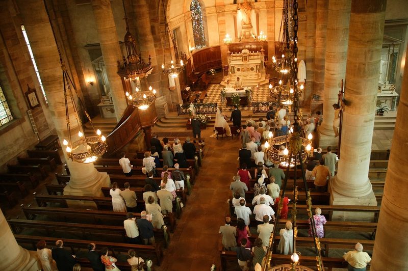 Interior de iglesia iluminado con luz cálida durante una ceremonia
